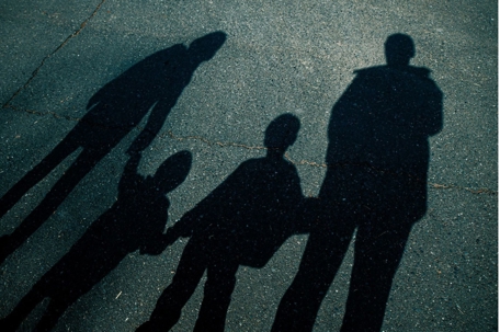 Shadow of parents and child walking together, representing family dynamics and child custody considerations.
