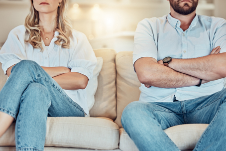 couple sitting on a couch with arms crossed