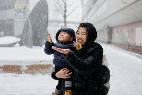 mother and son playing in the snow
